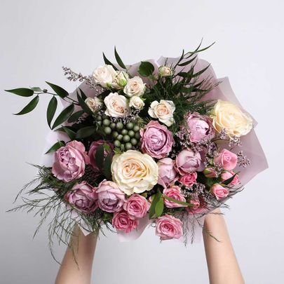 Frau mit Blumenstrauß aus schönen Rosen auf hellem Hintergrund